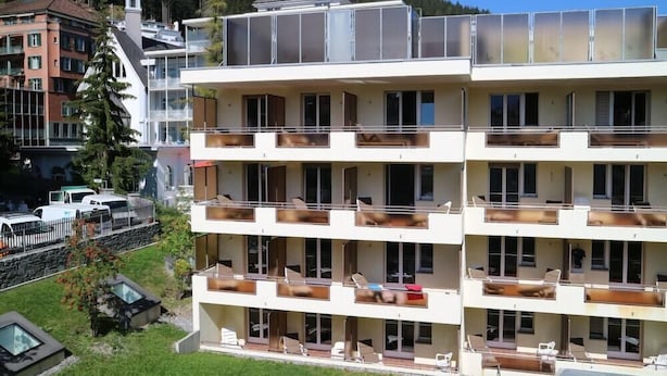 A multi-story hotel with balconies, a ski lift, and a mountain backdrop. - Spengler Hostel (Davos)