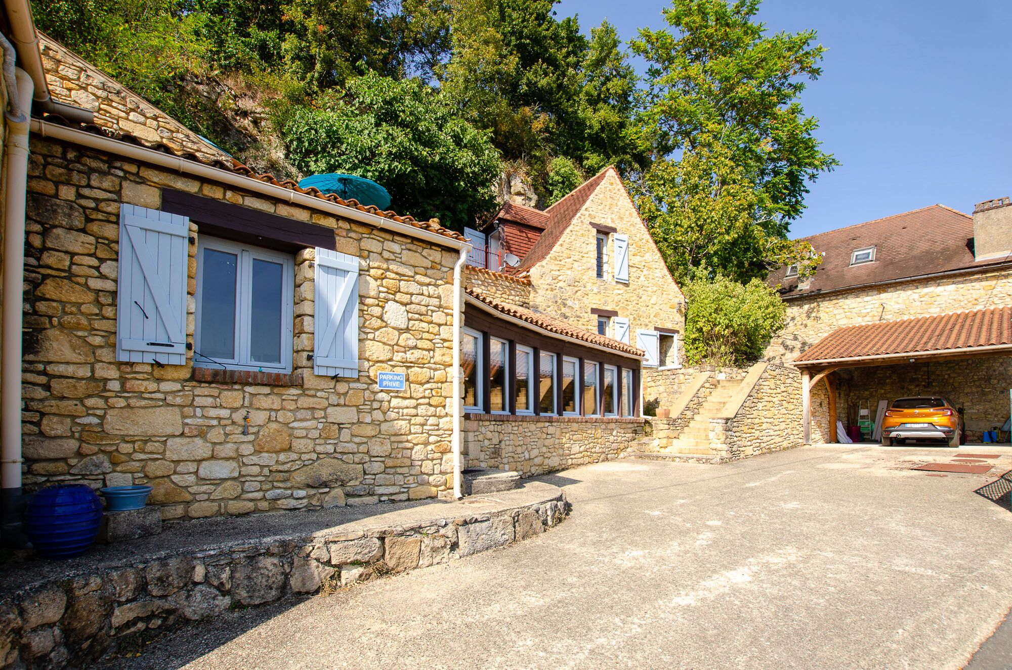 Un bâtiment en pierre avec une pancarte indiquant un espace de stationnement.