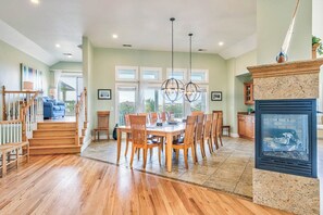 A spacious living room with a wooden staircase, a dining area with a round table and chairs, and a fireplace. - Sea View II | 245 ft to the beach | Private Pool, Hot Tub (Southern Shores)