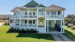 A two-story house with a front porch, a garage, and a small deck. - Sea View II | 245 ft to the beach | Private Pool, Hot Tub (Southern Shores)