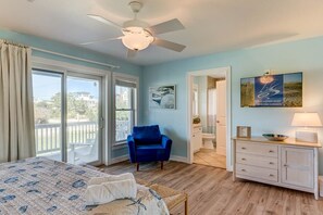 A bedroom with a bed, a chair, a dresser, and a ceiling fan. - Sea View II | 245 ft to the beach | Private Pool, Hot Tub (Southern Shores)