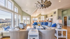 A spacious living room with a large window, a ceiling fan, and a view of the outside. - Sea View II | 245 ft to the beach | Private Pool, Hot Tub (Southern Shores)