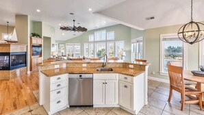 A spacious kitchen with a central island, white cabinetry, and a dishwasher. - Sea View II | 245 ft to the beach | Private Pool, Hot Tub (Southern Shores)