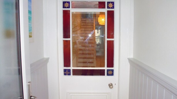A white door with a stained glass window and a brass door knocker. - Stunning townhouse at Plymouth Hoe (Plymouth)