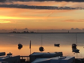 Ein Yachthafen mit vertäuten Booten im ruhigen Wasser bei Sonnenuntergang.