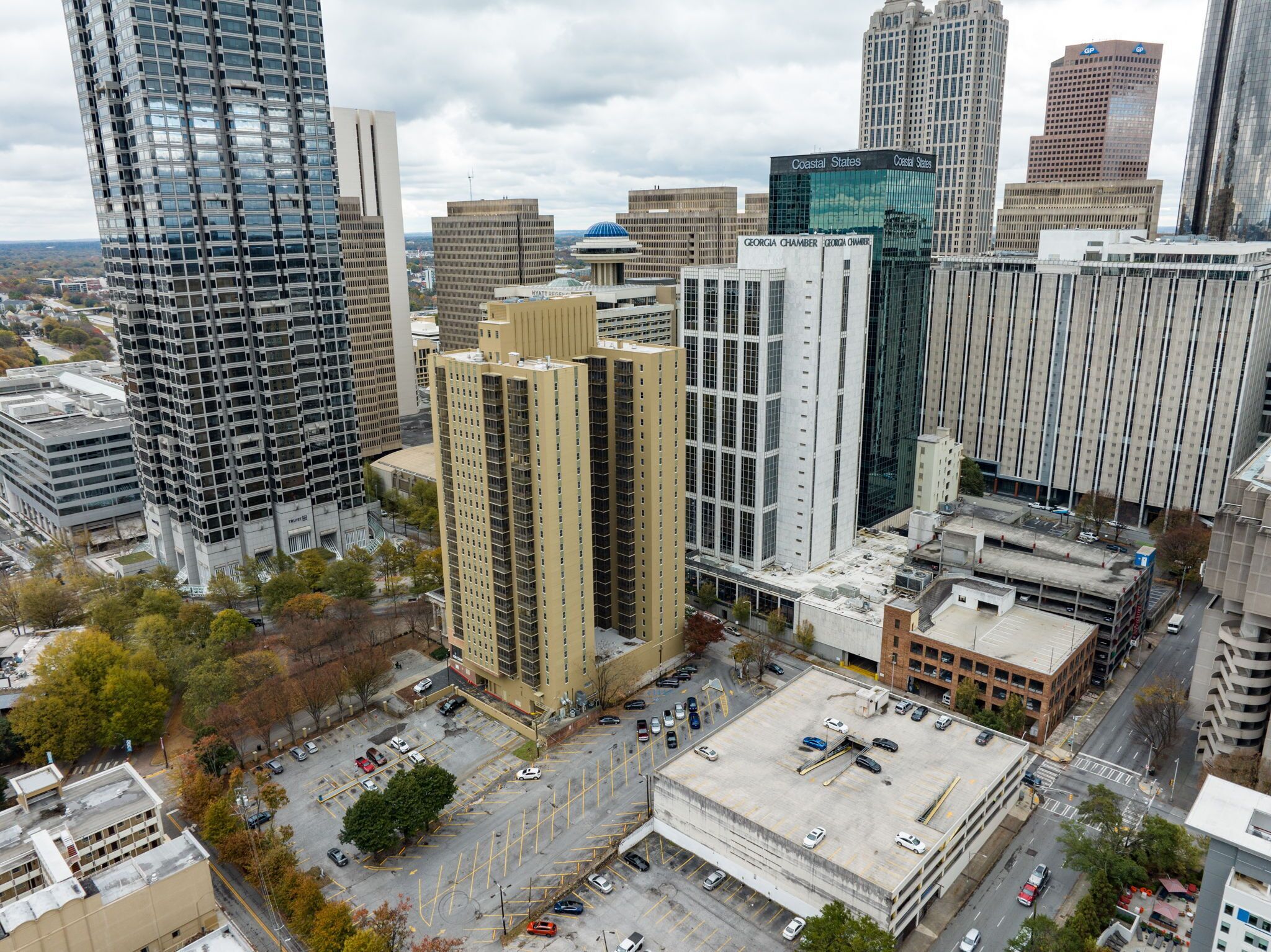 A high-rise building with a modern glass facade, surrounded by other tall buildings in an urban setting.
