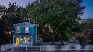 A two-story house with a porch and a white picket fence. - Vibrant, Historical Escape in Phoebus! (Hampton)