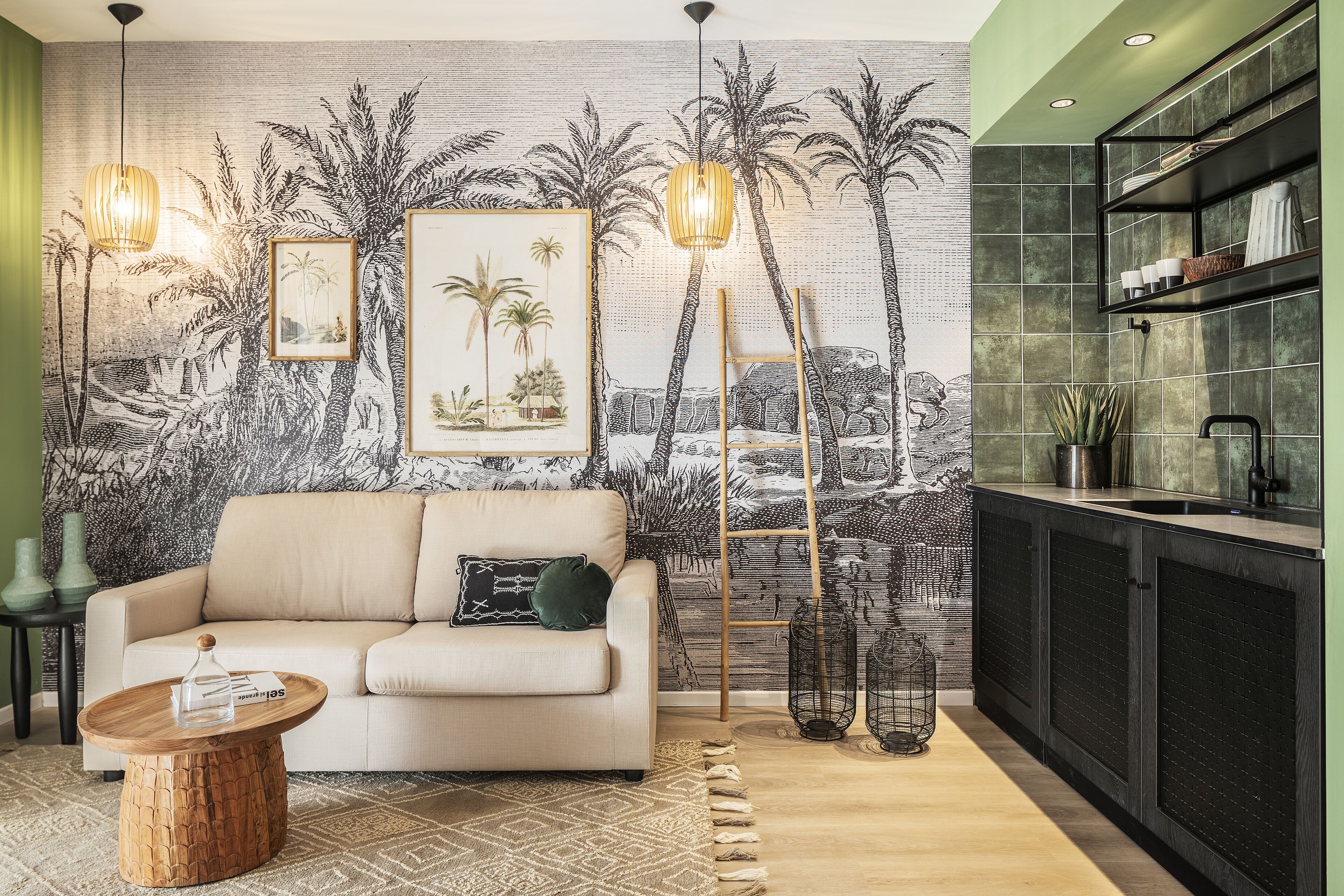 Una sala de estar con un sofá color beige, una mesa de centro de madera, un tapete estampado y un mural de palmeras en la pared.