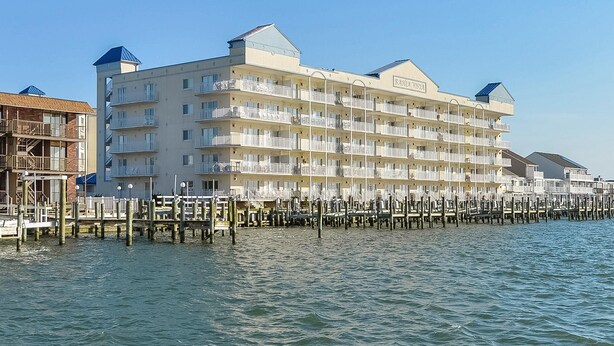 A multi-story hotel with balconies, located by the water. - Beautiful, with a great floor plan, in down town OC, walk to beach &boards, has an outdoor pool. (Ocean City)