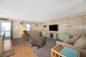 Relax in this inviting living room with a sofa, recliner, and fireplace, perfect for unwinding.