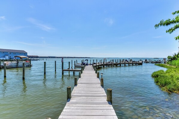 Guests can enjoy a serene waterfront experience from the pier, leading to a dock area with moored boats.
