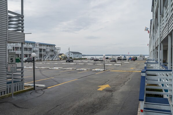 A parking lot with multiple cars, a speed limit sign, and a directional arrow on the road.