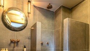 A modern bathroom with a large mirror, a sink, and a shower. - Designer Provenza Flat (Medellín)