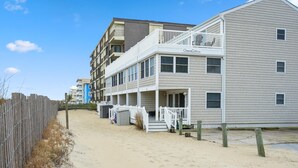 A beachfront hotel with a balcony, multiple windows, and a name sign. - Ocean Colony 28 at 47th St.  4 br/ 3 ba, oceanfront townhouse with outdoor pool. (Ocean City)