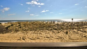 A beach with sand dunes and a wooden fence. - Sand Trap 102 - 2br/2ba oceanfront in area of low beach congestion. (Ocean City)