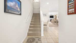 A staircase leading to a dining area with a view of the ocean city.