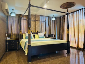 A four-poster bed with a canopy, a bedside table, a nightstand, and a wall-mounted air conditioner.