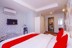 A hotel room with a bed, a television, a wardrobe, a desk, and a small table. - OYO 562 K Garden Hotel (Sungai Petani)
