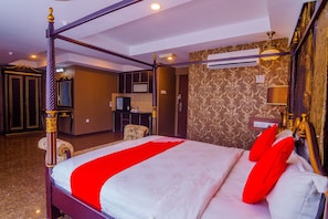 A four-poster bed with a red bedspread and pillows, a television in the background, and a patterned wallpaper on the walls. - OYO 562 K Garden Hotel (Sungai Petani)