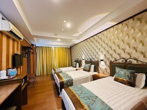 A hotel room with two beds, a desk, a television, and a curtain.