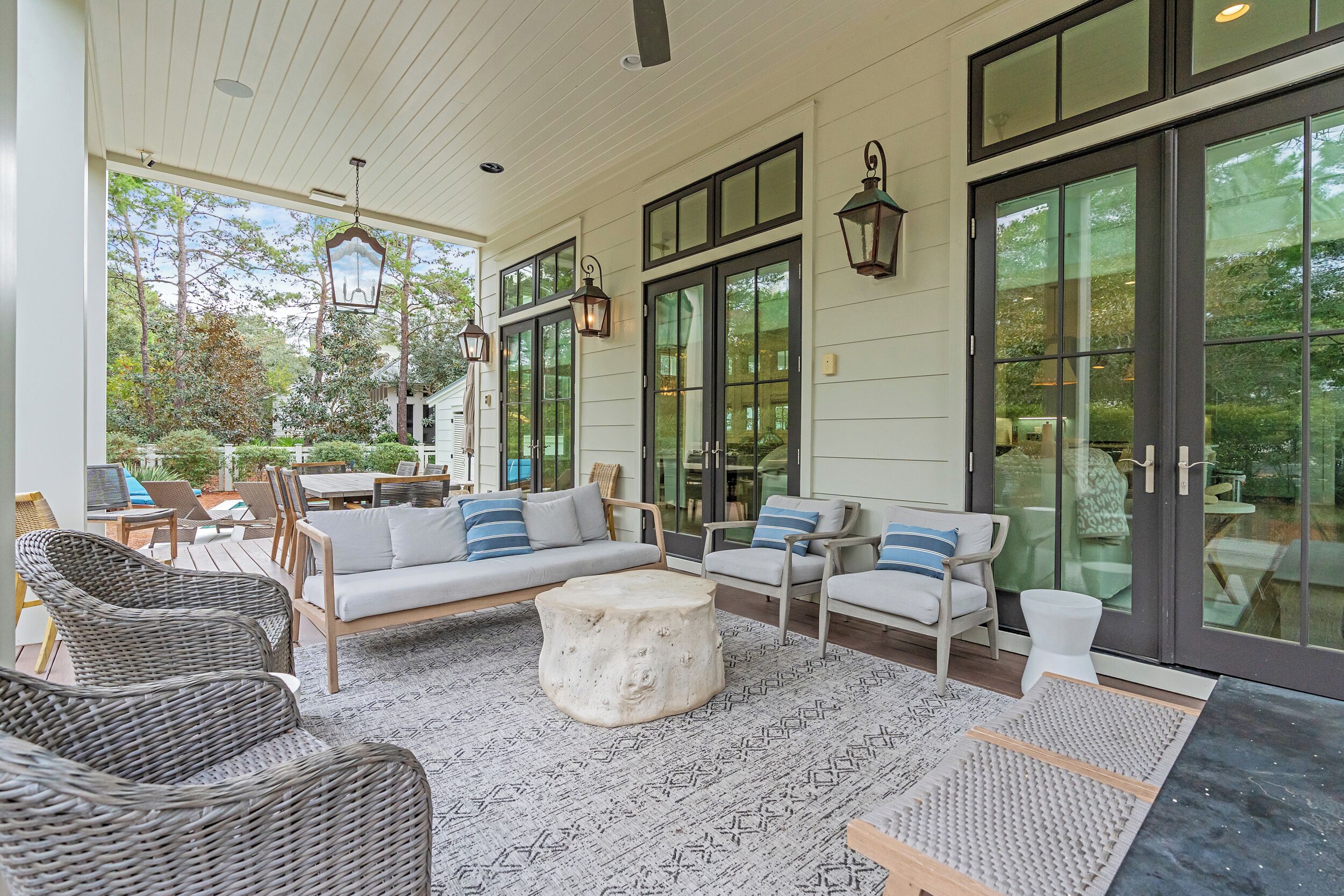 A spacious outdoor seating area with wicker chairs, a sofa, and a round table.