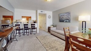 A modern apartment with a kitchen, dining area, and living room.