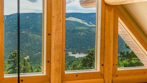 Eine Holzhütte mit großen Fenstern, die einen Blick auf eine Berglandschaft bieten.