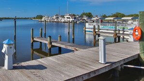 A marina with boats docked, a wooden pier, and a lifebuoy.
