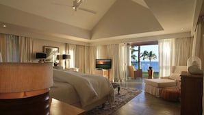 Ein geräumiges Schlafzimmer mit einem großen Bett, einem Fernseher und Blick auf den Ozean.