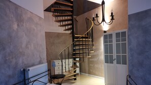 A bedroom with a bed, a dresser, a chest of drawers, a staircase, and a door. - Vacation apartment "Villa am Kurpark" - Maisonette (Friedrichroda)