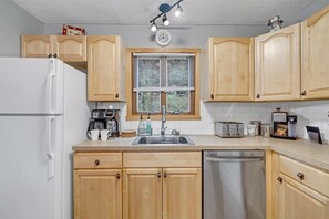 Kitchen with sink, stainless steel faucet, and various appliances.