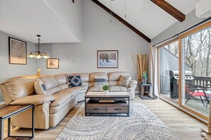 Relax in this stylish living room with a large sofa, wooden coffee table, and framed artworks on the walls.
