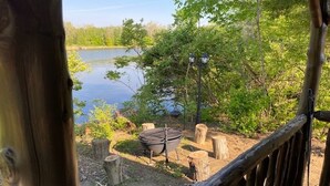 A wooden deck overlooking a lake with a grill and lanterns. - Big Mike's Cabin on the lake, next to ball diamonds nestled in 3 -cabin village (Hamersville)