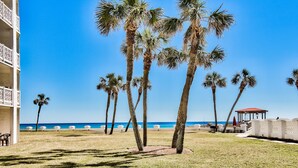 A beachfront property with palm trees, a gazebo, and a pool area. - El Matador 316 by AJH Rentals FREE BEACH SERVICE+ACTIVITIES! $300/Day (Fort Walton Beach)