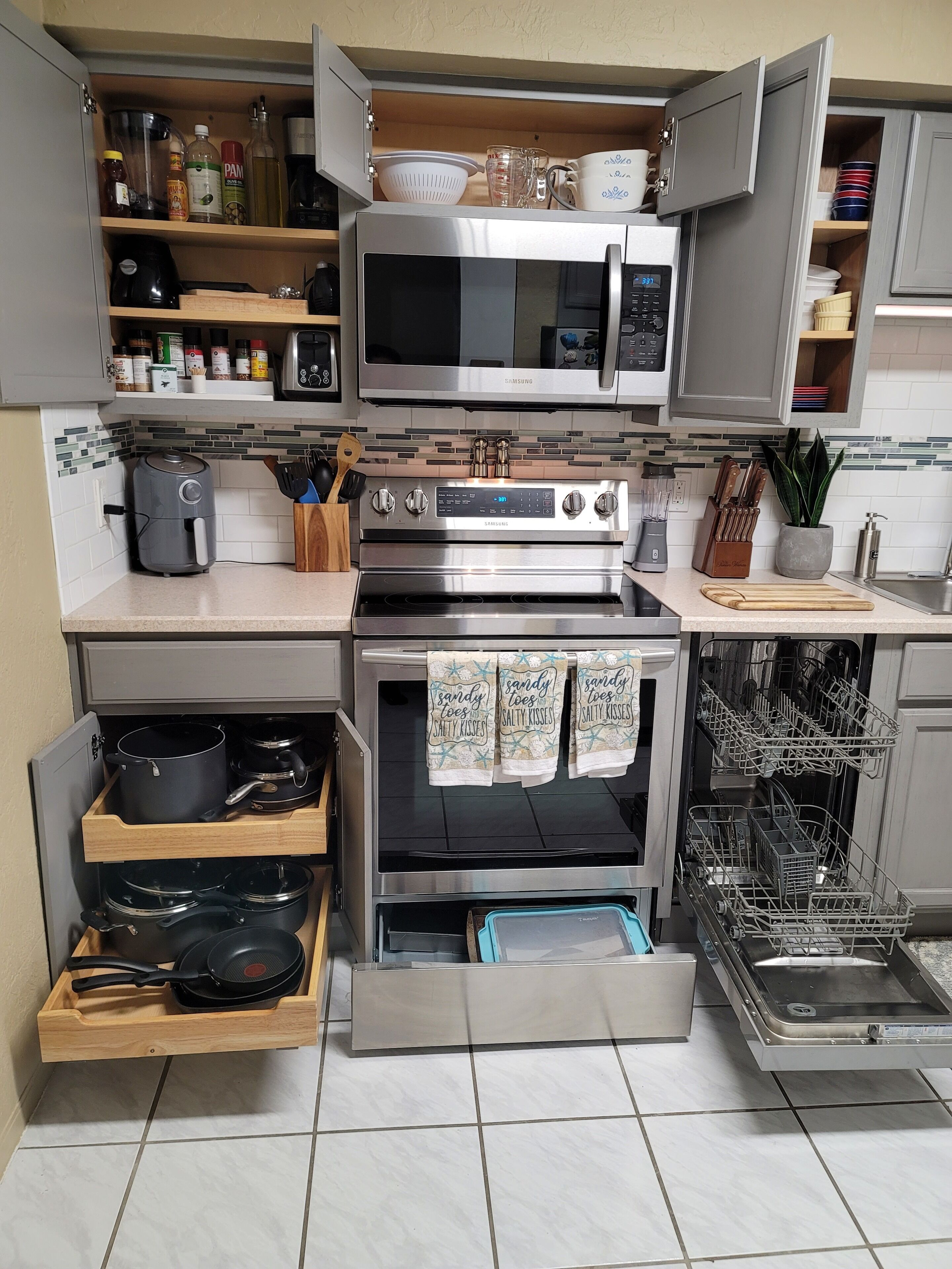 A compact kitchen with a microwave, oven, and dishwasher.