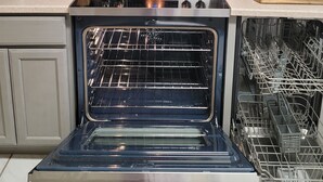 Una cocina equipada con microondas, horno y lavavajillas.
