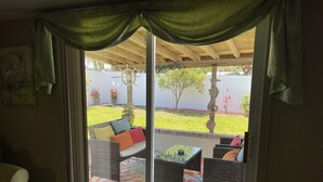 Una habitación con puerta de vidrio corrediza que da a un patio exterior.