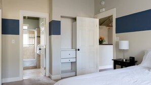 A hotel room with a bed, a nightstand, a desk, a wardrobe, and a bathroom visible through an open door. - Spacious, Soaring Ceilings, Near Downtown MV, GOOG (Mountain View)