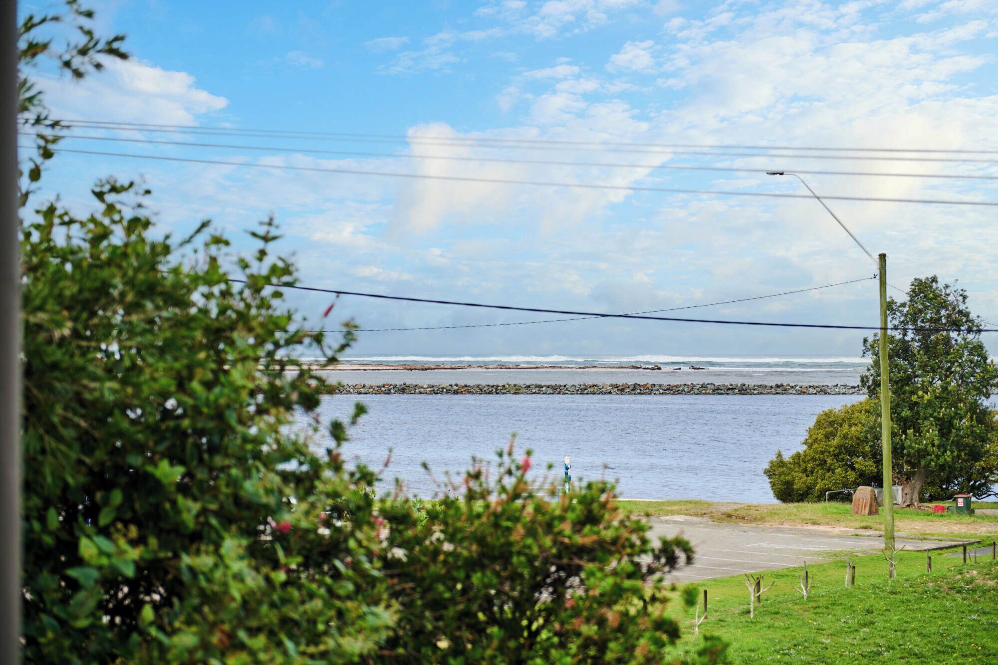 A view of a coastal area with a rocky shoreline, a clear sky, and a body of water.