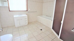 Ein Badezimmer mit Waschbecken, Waschtisch, Badewanne und Toilette.