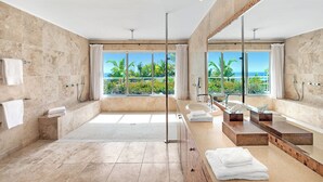 Une salle de bain moderne dotée d’une grande baignoire, d’une douche séparée et d’un meuble-lavabo avec un miroir.