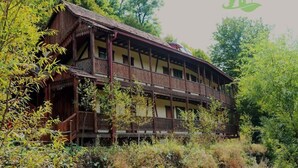 A traditional wooden building with a balcony, surrounded by dense foliage. - Ecokayan Boutique Hotel & Camping (Dilijan)