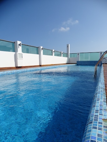 Una piscina al aire libre, sillones reclinables de piscina