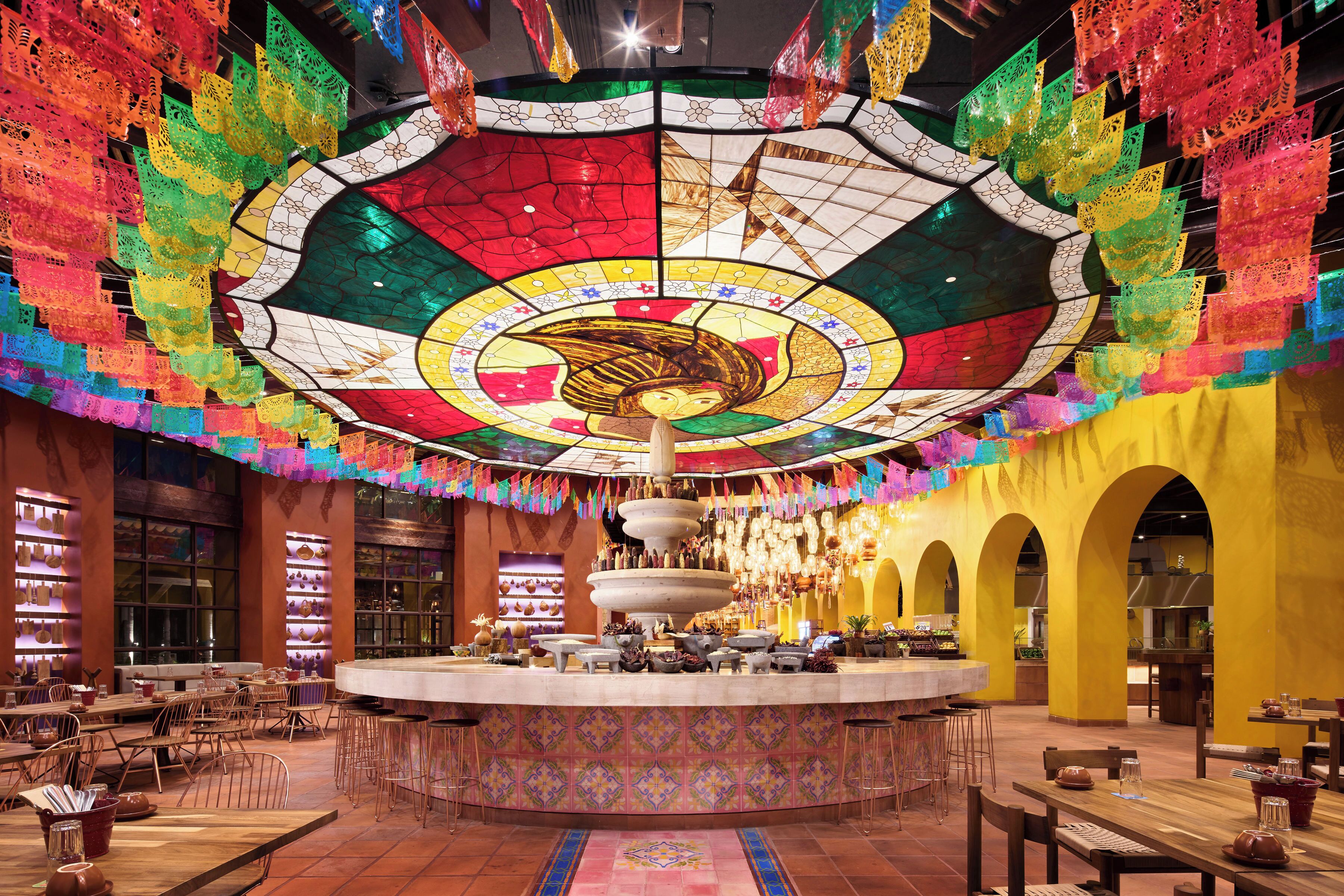 Un restaurant doté d’une fontaine centrale, avec des tables et des chaises disposées autour.
