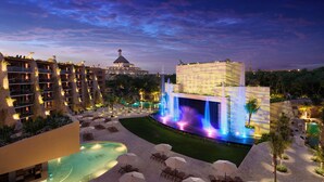 A resort with a pool, outdoor seating, and a waterfall feature. - Hotel Xcaret Arte - All Parks / All Fun Inclusive, Adults Only - All inclusive (Playa del Carmen)
