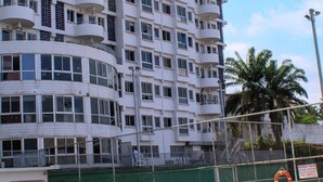 A multi-story hotel with balconies, a swimming pool, and a fenced area with a lifebuoy. - Residence Les Hauts de L Indenie (Abidjan)