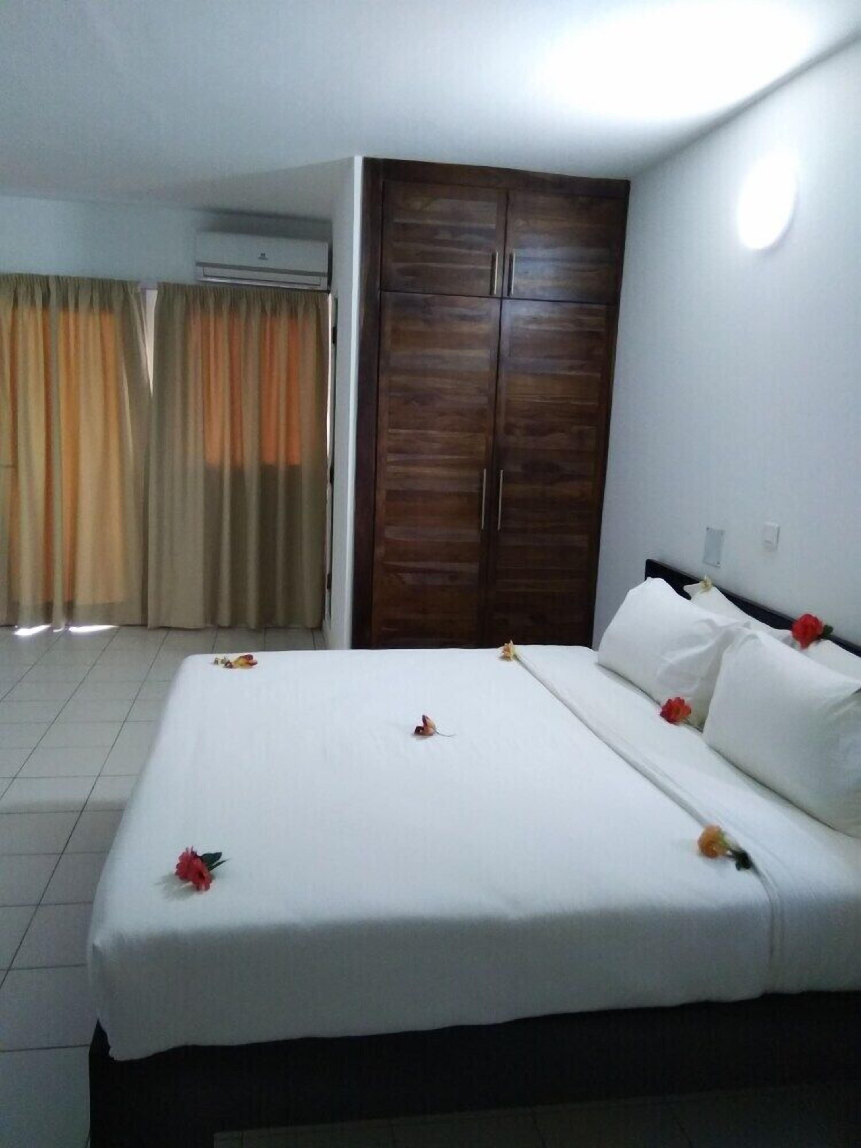 Ein Hotelzimmer mit Bett, Kleiderschrank und Vorhang.