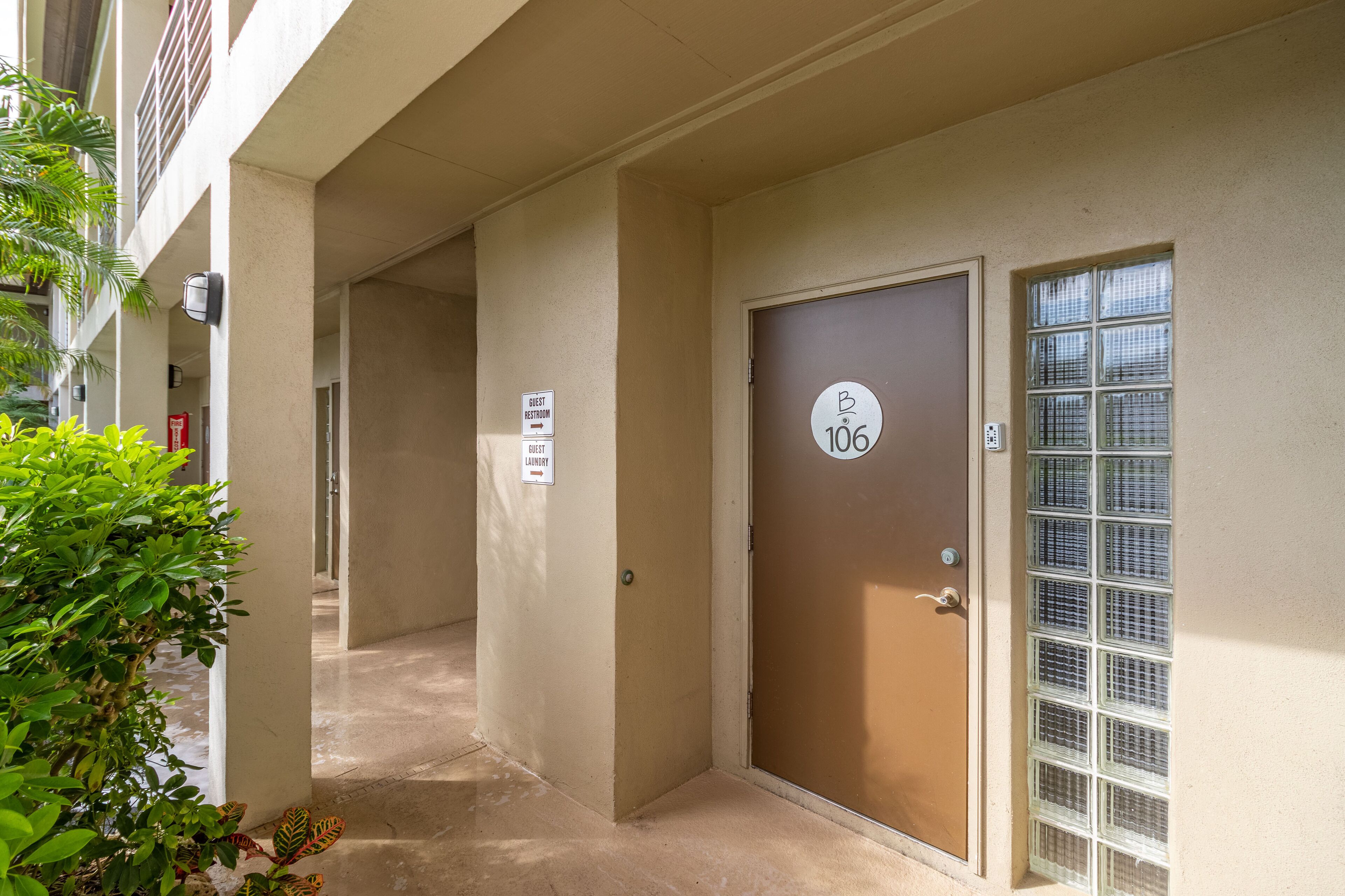 Un couloir avec une porte portant le numéro « 106 » et des panneaux indiquant l’emplacement des toilettes pour les clients et des locaux pour la blanchisserie.