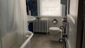 Ein Badezimmer mit Badewanne, Toilette und Fenster.