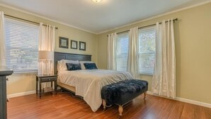 A bedroom with a bed, bedside table, and a bench. - Kimball Cottage (Richland)